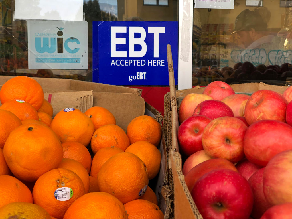 A sign noting the acceptance of electronic benefit transfer cards for food aid is displayed at a grocery store in California. Upcoming shifts in the federal food stamp program are poised to cost states billions of dollars, raising fears that more Americans will lose access to the nationβs largest food assistance program. (Photo by Justin Sullivan/Getty Images)