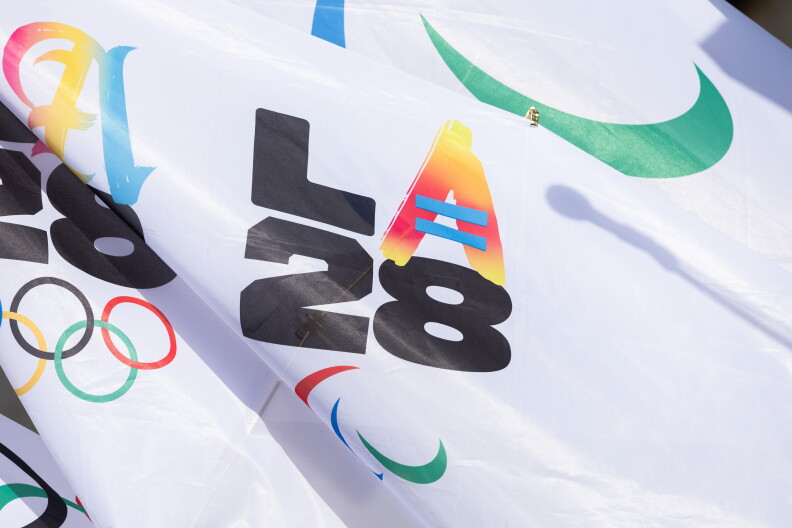 A flag in colorful letters and numbers reads "LA28".