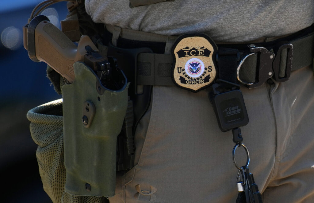 An Immigration and Customs Enforcement officer's badge and weapon are seen during a vehicle checkpoint on Georgia Ave. in Washington, D.C., on Aug. 30, 2025. (Photo by Kevin Dietsch/Getty Images)