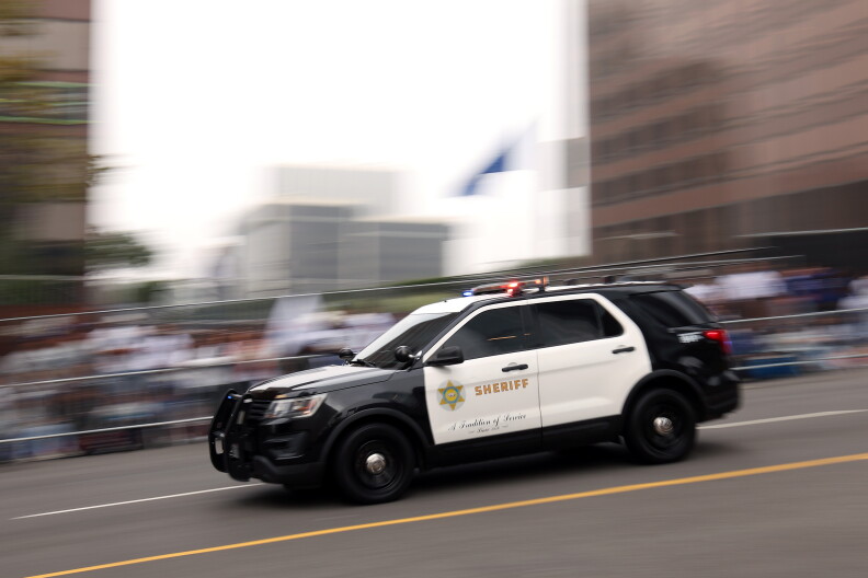 Black and white patrol car is seen against a blurred background.