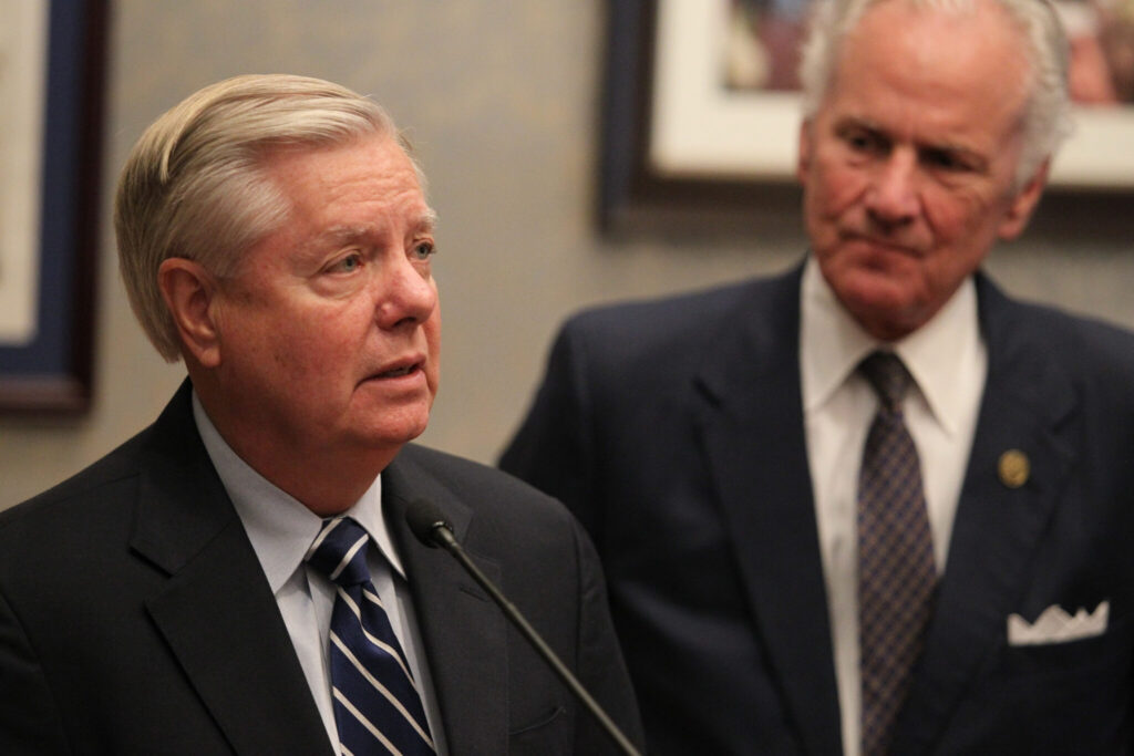 U.S. Sen. Lindsey Graham speaks as South Carolina Gov. Henry McMaster looks on during a press conference in the governorβs office at the Statehouse in Columbia, South Carolina, on Aug. 9, 2022. (File photo by Travis Bell/STATEHOUSE CAROLINA/Special to the SC Daily Gazette)