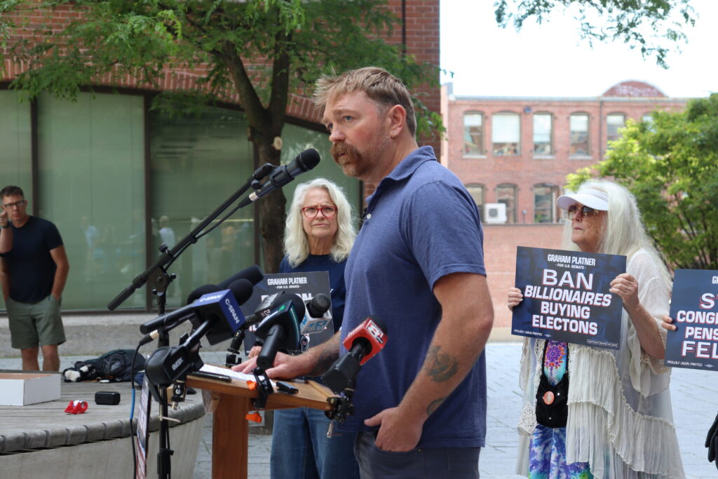 Graham Platner, then the Democratic nominee for the U.S. Senate in Maine, unveils an anti-corruption policy plan outside the Portland office of incumbent Republican U.S. Sen. Collins on June 25, 2026. (Photo by Emma Davis/ Maine Morning Star)