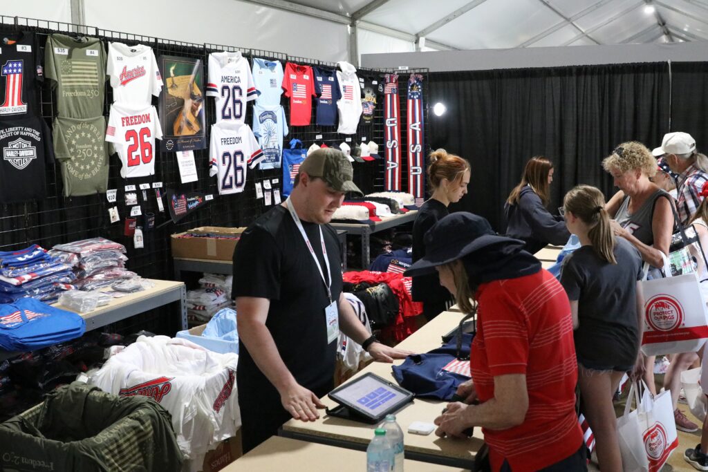 Merchandise tied to America’s 250th birthday is sold in a stall at Freedom 250’s Great American State Fair in Washington, D.C., on June 30, 2026. (Photo by Sam Gauntt/States Newsroom)