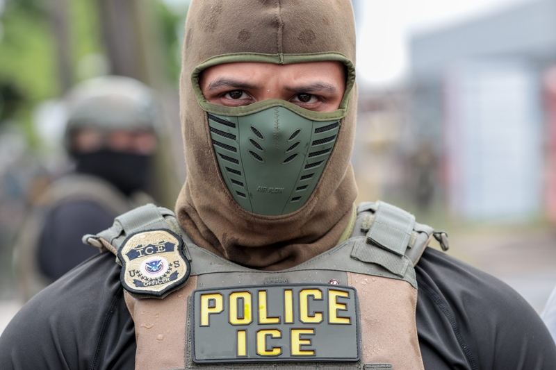 A U.S. Immigration and Customs Enforcement officer watches a crowd of protesters at Delaney Hall in Newark, New Jersey, on May 25, 2026. (Photo by Ben Ackman/New Jersey Monitor)