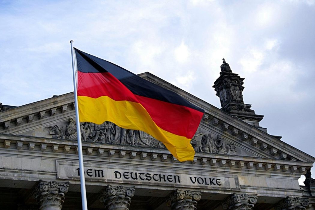 German flag in front of the Reichstag Building in Berlin, Germany.
