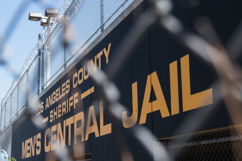 A Men's Central Jail sign is visible beyond a chain-link fence.