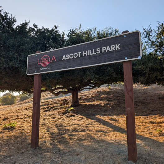 A sign on a small slop that says "Ascot Hills Park"