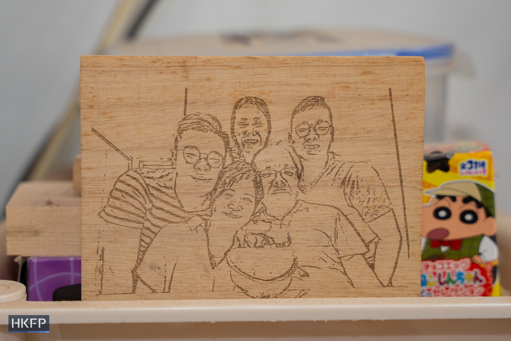 A laser printed picture of Siu's family made by Sylvester Siu displayed in an industrial building in Kwai Chung, June 12th, 2026. Photo: Kyle Lam/HKFP.