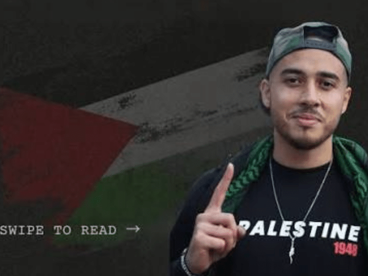 Ahmad Hajahmad Jarrar, a pro-Palestine activist, smiles with his index finger pointing up in a baseball cap turned backwards and a scarf draped on his shoulders. His jumper has 'Palestine' printed on it