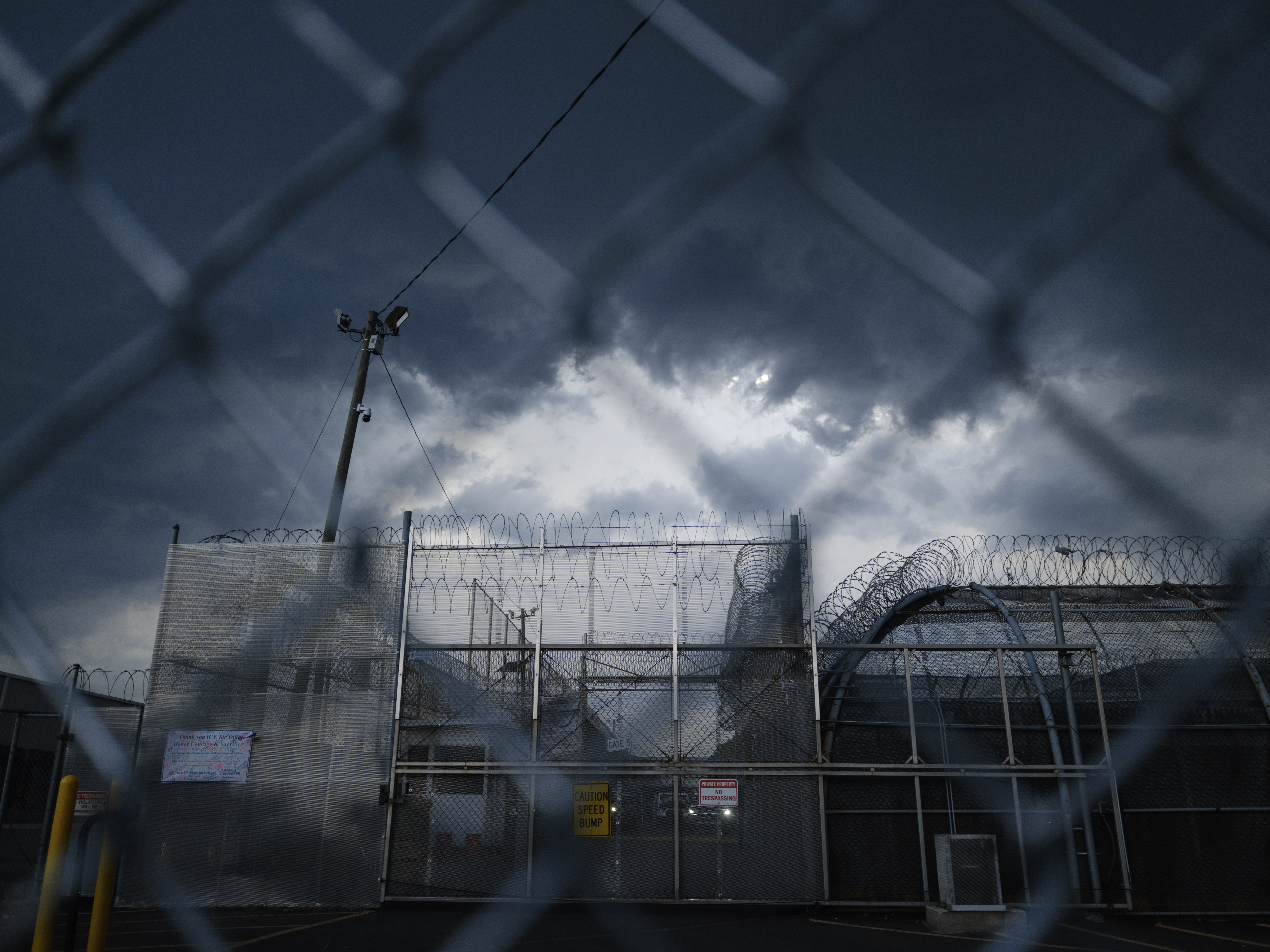 A storm passes over the Delaney Hall Detention Facility as activists continue to protest outside.