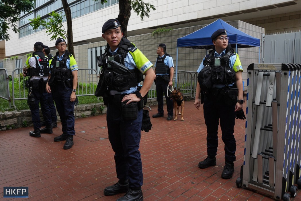 Hong Kong police set up a cordon outside the West Kowloon Law Courts Building on August 21, 2026, ahead of the verdict hearing of the trial of two Tiananmen vigil activists Chow Hang-tang and Lee Cheuk-yan on national security charges. Photo: Kyle Lam/HKFP.