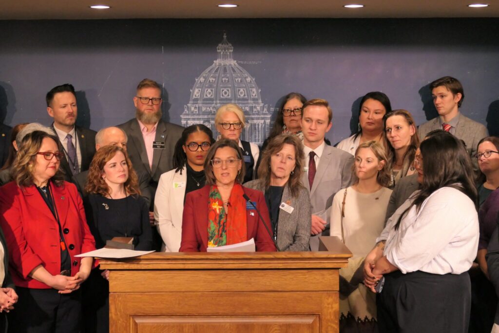 Montana state Sen. Cora Neuman, a Democrat, speaks at a January news conference in the Minnesota Capitol surrounded by state lawmakers from across the country amid a surge in immigration enforcement there. Democrats say they are increasingly organizing lawmakers across state lines to better compete with the influence of organized conservative groups. (Photo by Michelle Griffith/Minnesota Reformer)