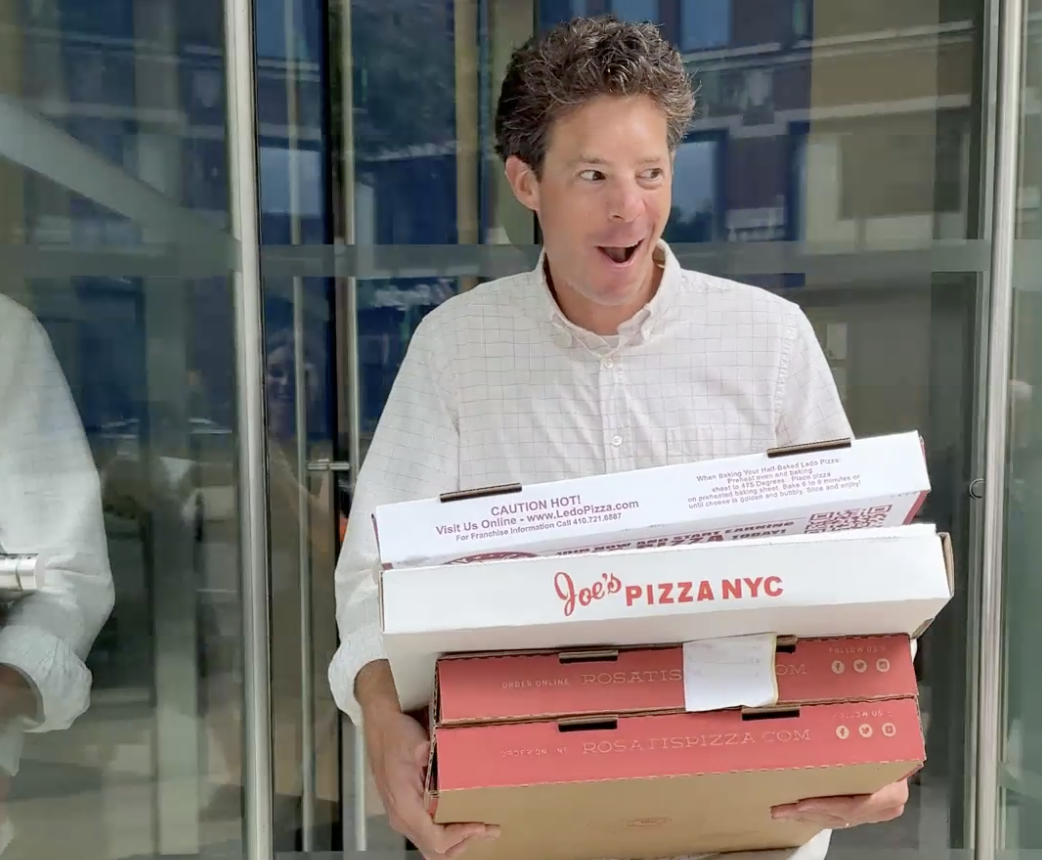 James carrying a bunch of pizzas