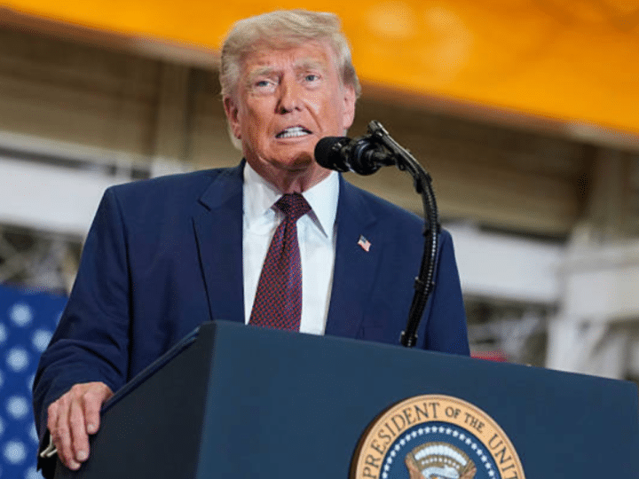Donald Trump at a mic stand mid-speech