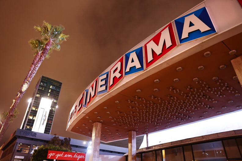 Closeup of a sign, hanging on a building, that reads, "cinerama."