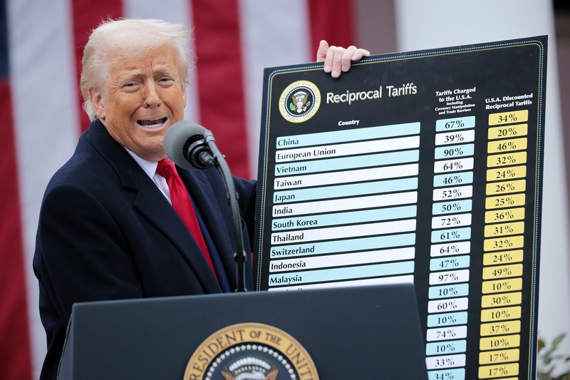 Trump holds up a chart while speaking during an event in the Rose Garden at the White House on April 2, 2025. Touting the event as “Liberation Day,” Trump announced additional tariffs targeting goods imported to the U.S. (Photo by Chip Somodevilla/Getty Images)