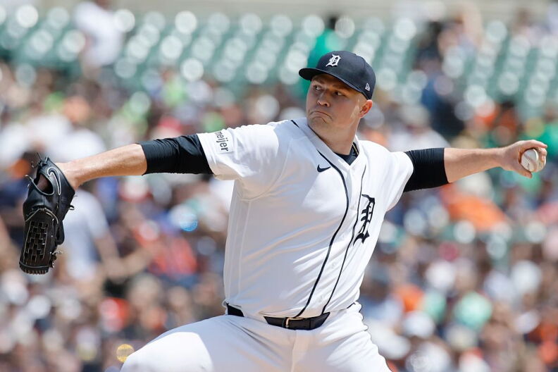 A man in a Detroit Tigers baseball uniform in the middle of a pitch