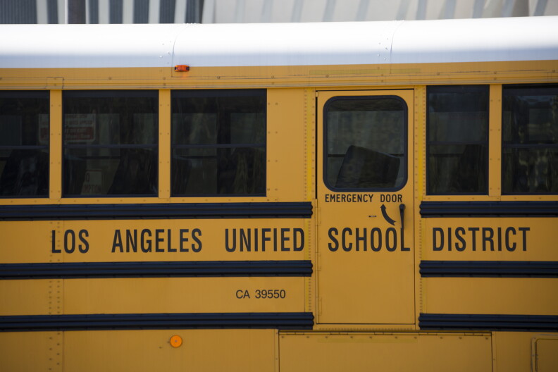 A close up of a yellow school bus with text on the side that reads "Los Angeles Unified School District."