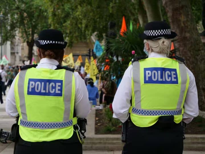 Two uniformed police officers walking with their back to the camera. Hackers have infilrated the national police system.