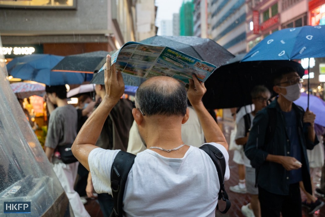 People walk in rain on July 15, 2026 in Mong Kok. Photo: Kyle Lam/HKFP.