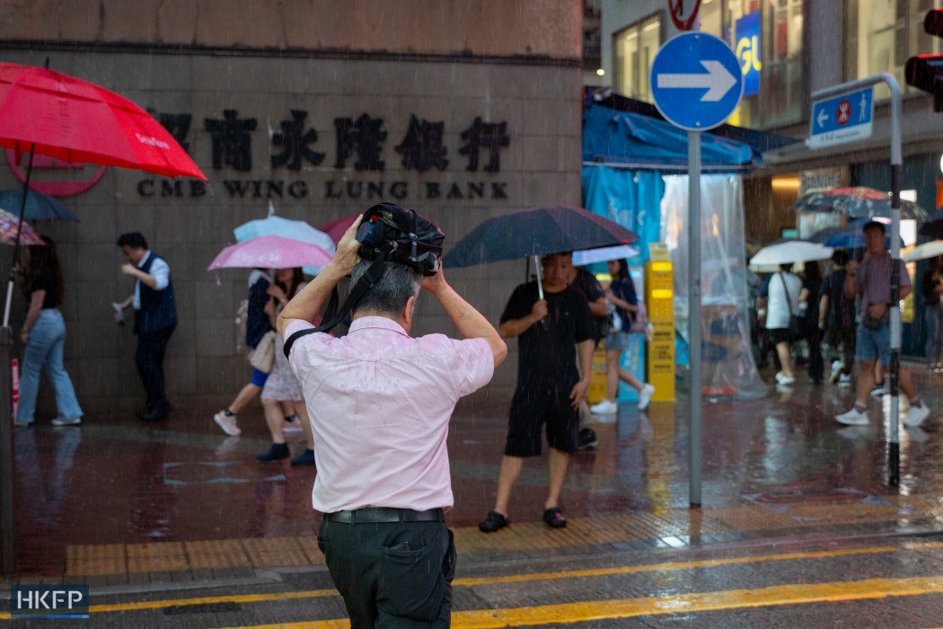People walk in rain on July 15, 2026 in Mong Kok. Photo: Kyle Lam/HKFP.