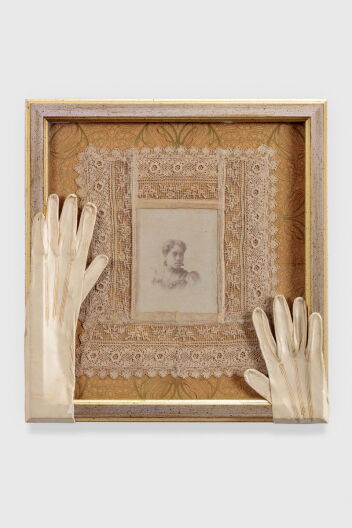 A framed art work of a photo an lace, and gloves on top of the frame.