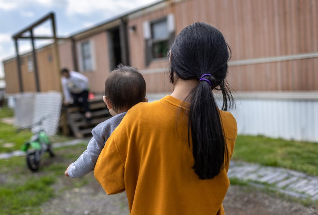 A 10-year-old Honduran immigrant who came into the United States as an unaccompanied minor carries her baby cousin on April 25, 2021, after reuniting with extended family in Sellersburg, Indiana. (Photo by John Moore/Getty Images)
